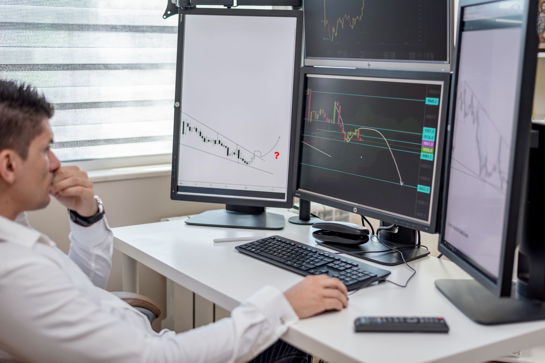 IT analyst working at multiple computer monitors